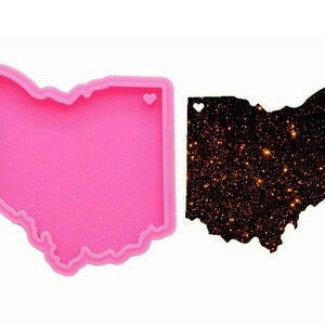 Könnte beinhalten: Rosa Silikonform in Form des Bundesstaates Ohio mit einem kleinen Herz-Ausschnitt. Die Form wird verwendet, um Kunsthandwerk aus Harz zu erstellen.