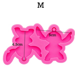 May include: Pink silicone mold shaped like two cartoon characters, one is 4.3 cm tall and the other is 5 cm wide. The mold is for making resin crafts.