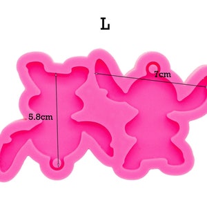 May include: Pink silicone mold for making two Stitch characters. The mold is 7 inches wide and 5.8 inches tall. The mold has a hole for hanging.