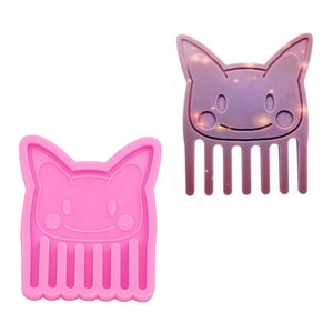May include: Pink silicone mold of a cartoon cat with a comb for hair. The mold is designed to create a resin cat comb.
