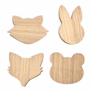 May include: Four unfinished wooden animal head shapes. The shapes are a fox, a rabbit, a bear, and another fox. The shapes are all cut out of wood and have a natural wood grain.