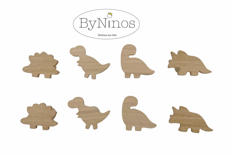 Op de afbeelding: Set van acht houten haken in de vorm van dinosaurussen. De haken zijn in de vorm van een stegosaurus, tyrannosaurus rex, brachiosaurus en triceratops. De haken zijn allemaal van natuurlijke houtkleur.
