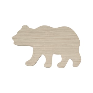 May include: A wooden bear cutout in the shape of a walking bear. The bear is light brown and has a wood grain texture.