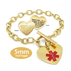 May include: Gold chain bracelet with two heart-shaped tags. The tags have engraved text with medical information, including the name "Janette Smith", medical conditions, and phone numbers. The bracelet also has a 5mm oval toggle clasp and a red medical symbol on a heart-shaped tag.
