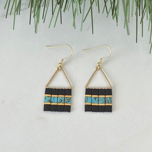 May include: A pair of gold dangle earrings with black and turquoise geometric bead designs.