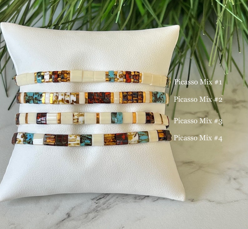 May include: Four stacked bracelets with a white background. The bracelets are made of small, colorful square beads. The text "Picasso Mix #1", "Picasso Mix #2", "Picasso Mix #3", and "Picasso Mix #4" is written on the right side of the image.