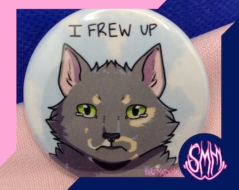 Puede incluir: Una chapa redonda con una ilustración de un gato gris de ojos verdes con expresión triste. El texto I FREW UP aparece impreso en negro sobre la cabeza del gato, y el texto SELF MADEMAN aparece en letras pequeñas en la parte inferior.