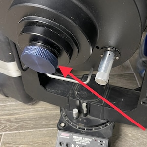 May include: A black telescope mount with a silver knob and a blue knob. The mount is labeled "MEADE LX200 SMART DRIVE".