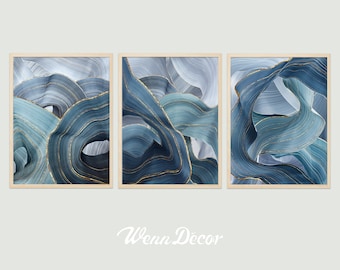May include: Three framed abstract art prints with blue and gold swirling patterns. The prints are in wooden frames and are arranged in a row.