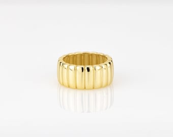 Könnte beinhalten: Ein goldfarbener Ring mit einem geriffelten, strukturierten Band.