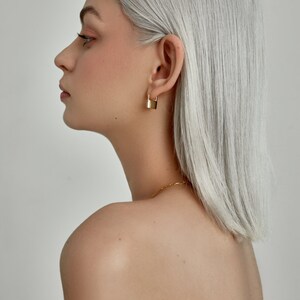 Model is wearing Gold Lock Hoops: dainty padlock charm, huggie Hoop Earrings