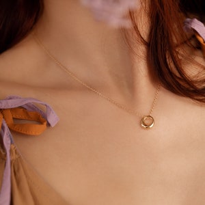 Our model is wearing OLIVIA, our simple french minimalist circle pendant necklace in gold