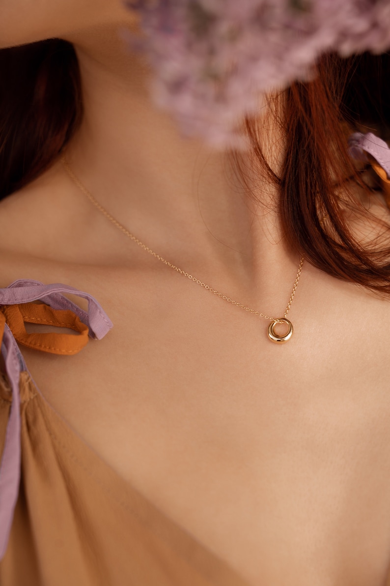 Our model is wearing OLIVIA, our simple french minimalist circle pendant necklace in gold