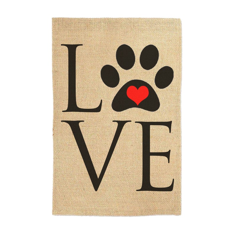 May include: A burlap garden flag with the word "LOVE" in black letters and a black paw print with a red heart in the center.