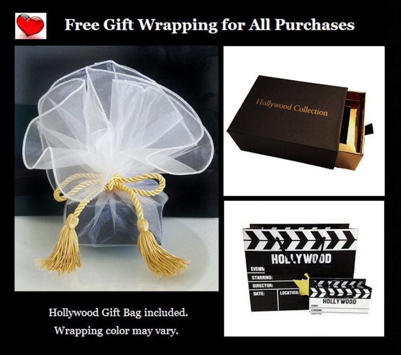 May include: A black gift box with a gold drawer and the text "Hollywood Collection" on the top. The box is wrapped in white tulle with gold ribbon and tassels. The image also shows a black and white clapperboard with the text "HOLLYWOOD" on it.