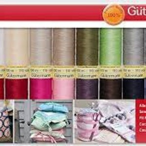 Pode incluir: Um pack de fios de costura Gütermann Creativ Value Pack em várias cores. As bobinas estão dispostas em filas, com uma mistura de tons vibrantes e neutros. A embalagem inclui o texto "100%" e "100m".