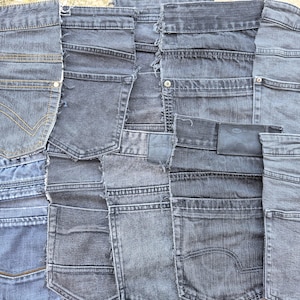 Könnte beinhalten: Eine Ansammlung überlappender Denim-Stoffreste in verschiedenen Grau- und Blautönen. Die Stücke zeigen sichtbare Gesäßtaschen, Metallnieten, Kontrastnähte, ausgefranste Kanten und ein rechteckiges Lederetikett auf einem der Stoffsegmente.