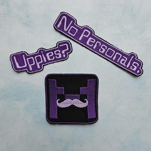 May include: Three embroidered patches with purple and black color schemes. One rectangular patch reads No Personals, one smaller patch reads Uppies?, and a square patch features a purple letter H with a light purple mustache graphic centered.