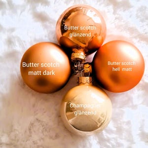Pu&ograve; includere: Quattro ornamenti natalizi nei toni dell'oro e del bronzo. Gli ornamenti includono un butterscotch lucido, un butterscotch opaco scuro, un butterscotch opaco chiaro e un ornamento color champagne lucido. Il testo sugli ornamenti recita "Butter scotch gl&auml;nzend", "Butter scotch matt dark", "Butter scotch hell matt" e "Champagner gl&auml;nzend".