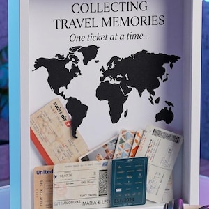 May include: A white rectangular shadow box frame featuring a black world map silhouette and the text "COLLECTING TRAVEL MEMORIES One ticket at a time..." filled with various airline boarding passes and travel tickets.