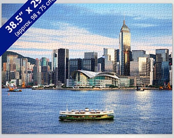 May include: A panoramic view of Hong Kong's skyline with skyscrapers, a ferry boat in the water, and a blue sky with white clouds.