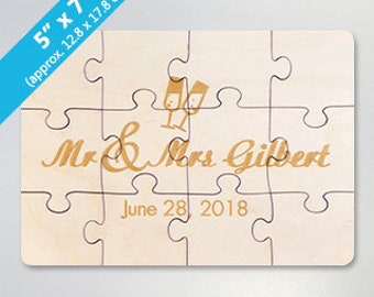May include: A 5" x 7" wooden jigsaw puzzle with a wedding theme. The puzzle features a couple's names, "Mr & Mrs Gilbert", and their wedding date, "June 28, 2018". The puzzle also includes a graphic of two champagne glasses.