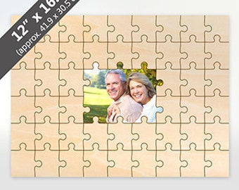 May include: A 12 x 16.5 inch wooden jigsaw puzzle with a photo of a couple in the centre. The puzzle is made of natural wood and has a light brown colour.