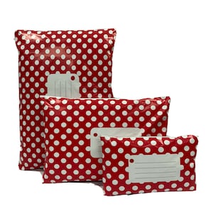 May include: Three red and white polka dot mailing envelopes of different sizes. Each envelope has a white address label with a blank space for writing.