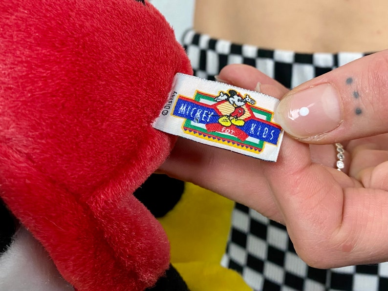 May include: Red and black plush Mickey Mouse toy with a yellow tag that reads "Disney Mickey for Kids".