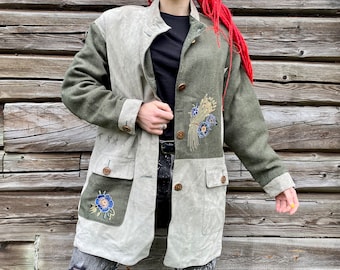 May include: A long, green and gray jacket with embroidered flowers and wheat. The jacket has a button closure and two pockets.