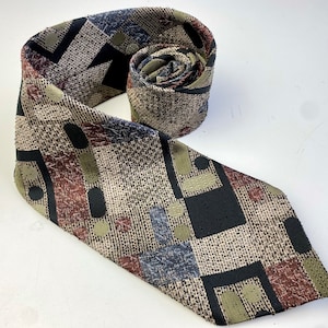 Puede incluir: Una corbata estampada con un diseño geométrico en tonos marrones, negros, beige y azules.