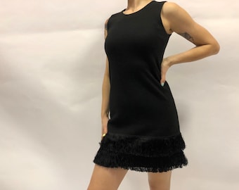 May include: A black sleeveless dress with a tiered fringe hem.