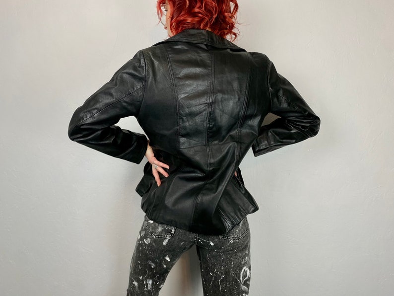 May include: Black leather jacket with a classic design. The jacket has a collar, long sleeves, and a front zipper closure.