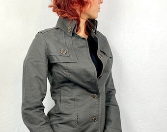 Peut inclure: Une veste utilitaire gris foncé avec un devant boutonné, un col et plusieurs poches.