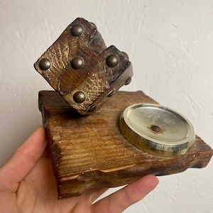 May include: A wooden base with a small, decorative wooden box with metal accents and a round, metal dish on top.