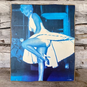 Falda de metro de lona de Marilyn Monroe levantada, fotografía borrosa con arte de filtro azul sobre lienzo de cartón prensado