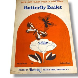 May include: A vintage sheet music cover titled Butterfly Ballet by John Chagy for solo piano. The cover features a large orange arch containing two brown butterflies and a white flower. Text includes David Carr Glover Program Solo Series.