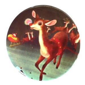 May include: A vintage Christmas ornament featuring a red reindeer with a white nose and a blue bubble. The reindeer is surrounded by other reindeer in a snowy scene.