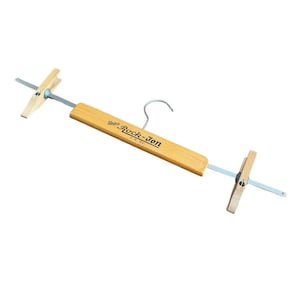 May include: A wooden clothes hanger with metal accents and a metal hook. The hanger has a light brown wooden bar with the text "Union Rock-Jon" printed on it. The ends of the hanger have wooden clips.