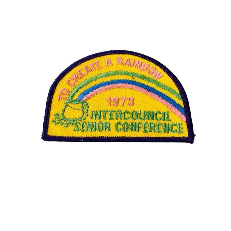 K&ouml;nnte beinhalten: Gelber gestickter Aufn&auml;her mit einem Regenbogen, einem Topf voll Gold und dem Text "To Create A Rainbow 1973 Intercouncil Senior Conference".