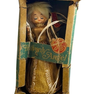 May include: Vintage General Electric "Heavenly Angel" Christmas tree topper in its original box. The angel is dressed in a gold gown with blonde hair and closed eyes. The box is green and gold with the GE logo.