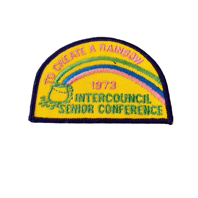 K&ouml;nnte beinhalten: Gelber gestickter Aufn&auml;her mit einem Regenbogen, einer gr&uuml;nen Tasche und dem Text "To Create A Rainbow 1973 Intercouncil Senior Conference".