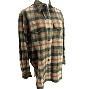 May include: A long-sleeved plaid shirt in shades of green, tan, and brown. The shirt features a button-down front, two chest pockets, and a collared neckline. The fabric has a textured appearance.