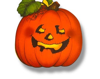 May include: An orange pumpkin with a carved face, featuring triangular eyes and a wide, grinning mouth. Green leaves and a brown stem are at the top. A traditional Halloween decoration.
