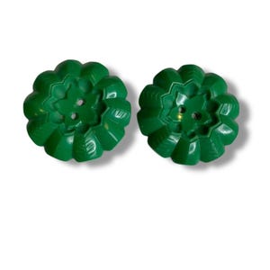 May include: Two bright green, flower-shaped buttons. Each button has a detailed, ridged design and three small holes for sewing. The buttons are made of a glossy material and are set against a white background.