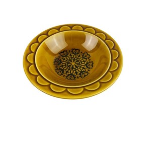 Puede incluir: Un tazón de cerámica amarillo con un diseño floral negro y verde. El tazón tiene un borde festoneado.