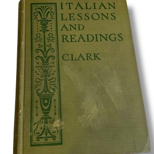 May include: A vintage book titled "Italian Lessons and Readings" by Clark. The cover is a muted green with the title in dark green lettering. An ornate green design is on the left side of the cover.