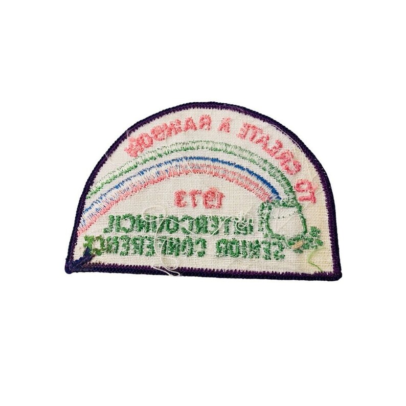 K&ouml;nnte beinhalten: Ein wei&szlig;er gestickter Aufn&auml;her mit einem Regenbogen und dem Text "СОВМЕСТНАЯ ИТАЛЬЯНО-СОВЕТСКАЯ КОМИССИЯ ПО СТРОИТЕЛЬСТВУ" in kyrillischer Schrift.