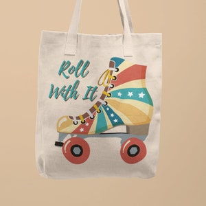 Può includere: Una borsa tote in tela bianca con un design di pattini a rotelle retrò e il testo "Roll with it".