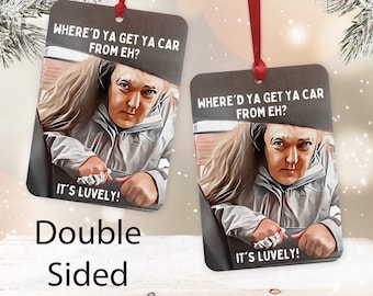 Könnte beinhalten: Doppelseitiger Weihnachtsschmuck mit einem Bild einer Person im Auto. Der Schmuck hat den Text "WHERE'D YA GET YA CAR FROM EH?" und "IT'S LUVELY!". Der rechteckige Schmuck wird von einem roten Band aufgehängt, ideal für festliche Dekorationen.
